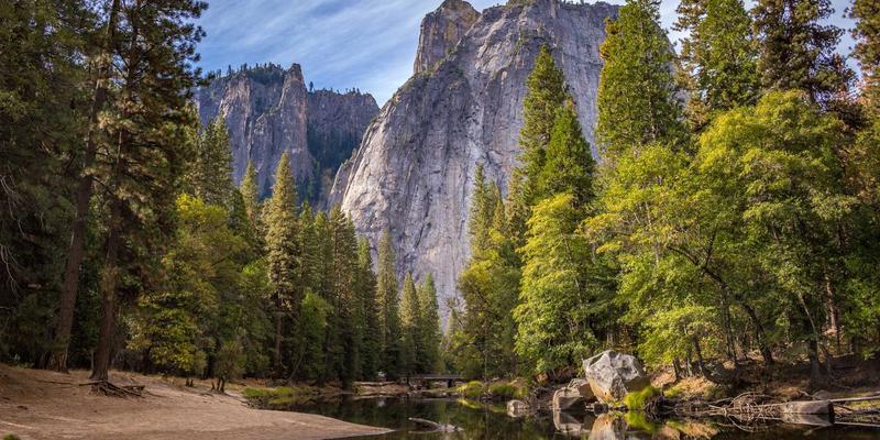 A beautifully styled nightstand featuring a modern lamp, a small potted plant, and a stack of design books.